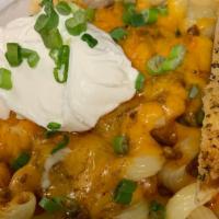Queso Chili Mac · Cavatappi noodles topped with house made Queso Chili, cheddar cheese, sour cream and chives....