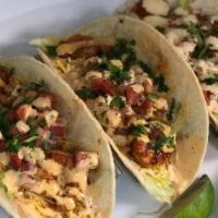 Three Fried Fish Tacos  · Three white corn tortillas filled with lettuce, fried parmesan tilapia, cheese pico and driz...