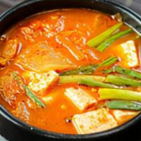 Kimchi Chigae · Kimchi, pork, tofu, fish cake, scallions, mushrooms and spicy pepper flakes in boiling kimch...