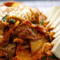 Kimchi Bokkeum · Pan fried pork, kimchi, rice cakes, scallions, onions and fresh slabs of tofu on the side.