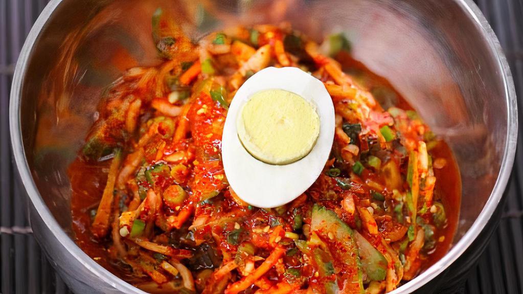 Bibim Naeng Myun · Pickled radish, cucumber slices, jalapenos, scallions and hard-boiled egg set atop a mound of sweet & spicy buckwheat noodles.