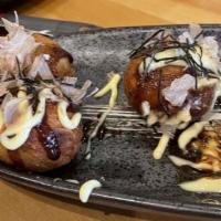Takoyaki (6) · Fried octopus ball topped with eel sauce and mayo. Finish with bonito and seaweed.