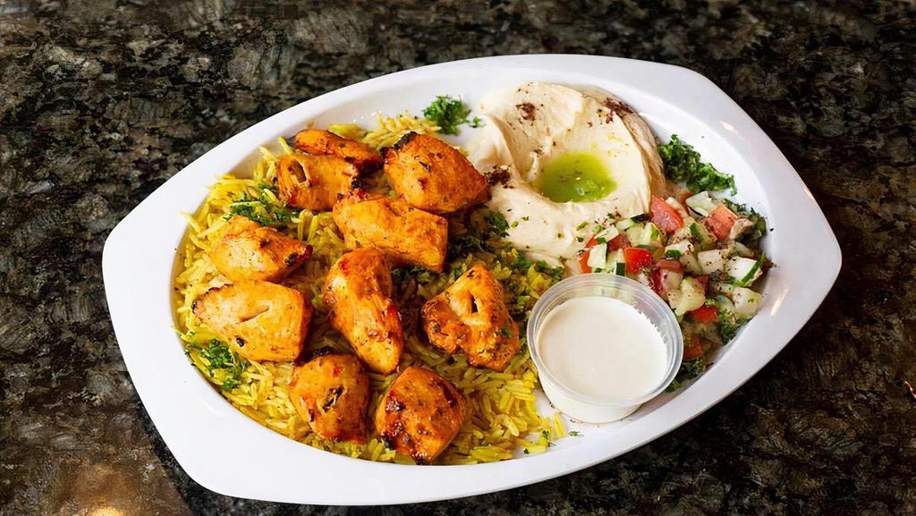 Chicken Shish Tawook Plate · Two skewers of marinated and juicy cubes of grilled chicken breast. (the plate comes with rice, Arabic salad, humas and 1 PC of pita bread).