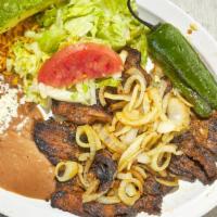 Carne Asada · Juicy steak topped with caramelized onions, one fried jalapeno, served with rice, beans, let...