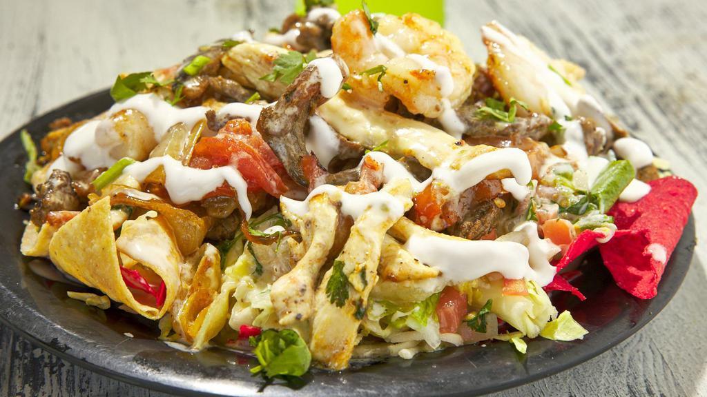 Pollo / Grilled Chicken Nachos · Grilled chicken, beans, shredded cheese, queso dip, lettuce, pico de gallo, jalapenos, sour cream.