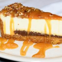 Turtle Cheesecake · New York-Style cheesecake, resting on a thick layer of fudge, covered with a rich caramel sa...