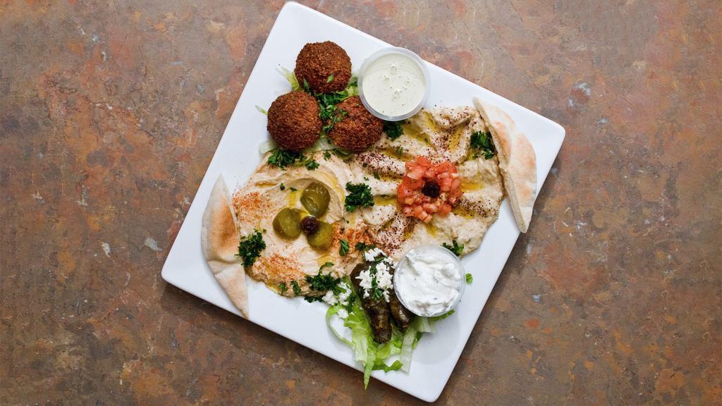 Maza Combination  · Hummus baba ghanouj two stuffed grape leaves, three falafel patties, feta cheese and Greek olives. Served with pita.