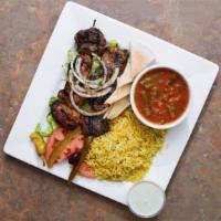 Lamb Kebab Dinner · Grilled seasoned lamb with garlic and black pepper served with rice, green beans, tahini sau...