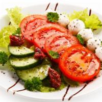 Caprese Salad · Fresh salad prepared with mozzarella cheese, tomato, and basil drizzled with balsamic vinaig...