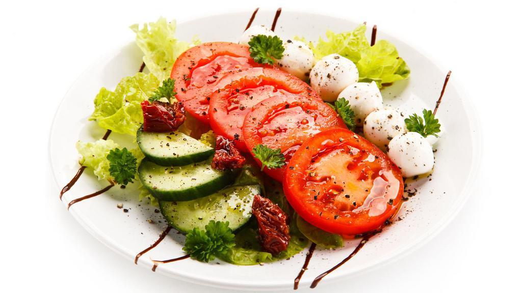Caprese Salad · Fresh salad prepared with mozzarella cheese, tomato, and basil drizzled with balsamic vinaigrette and sprinkled with salt and pepper.