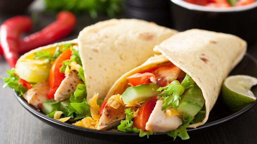 Cilantro Lime Chicken Wrap · Signature house wrap prepared with mixed greens, grilled chicken breast, black beans, pico de gallo and fresh diced mango, and topped with a house-made cilantro lime vinaigrette dressing. Served with chipotle sour cream and your choice of side.