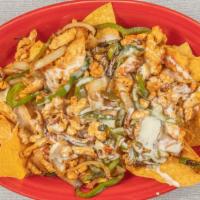 Fajitas Nachos · Get your meal off to a sizzling start! A plate of peppers, onions, and tomatoes atop a pile ...