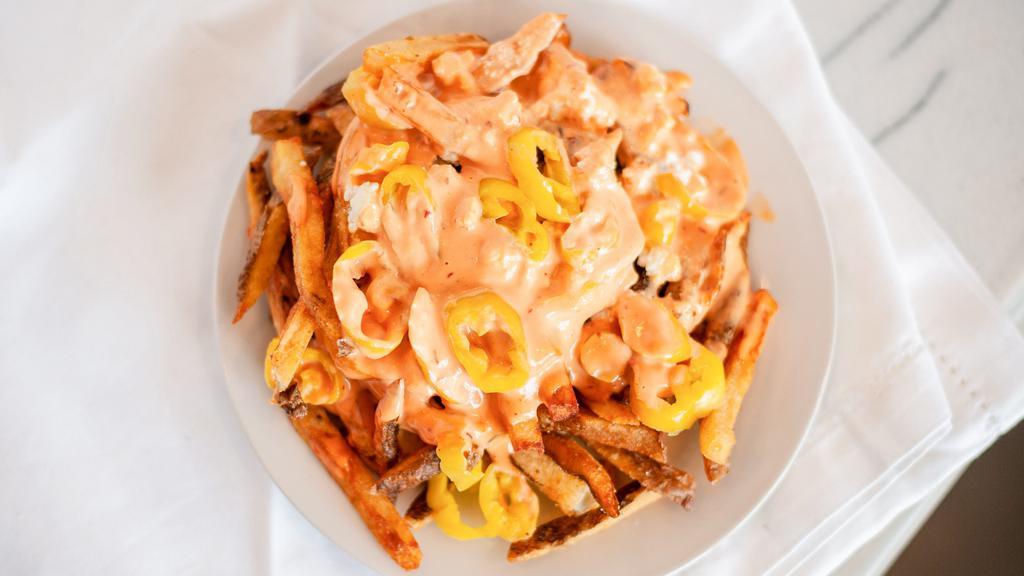 Mezze Fries · Our fresh cut fries smothered in feta, banana peppers, and Mezze sauce.