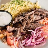 Beef Shawarma · Marinated beef seasoned and slowly cooked on a rotisserie. Thinly sliced and topped with tom...