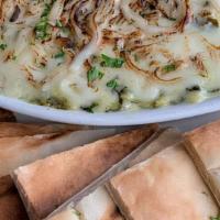 Spinach Artichoke Dip · A creamy blend of melted cheeses, Spinach and Artichokes. Served with a side of baked pita c...