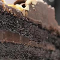 Triple Chocolate Mousse Cake · White and dark chocolate mousse on a sponge cake base, coated with chocolate and topped with...