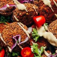 Falafel Salad · A combination of falafel, tomatoes, cucumbers, red cabbage, and romaine with a touch of lemo...