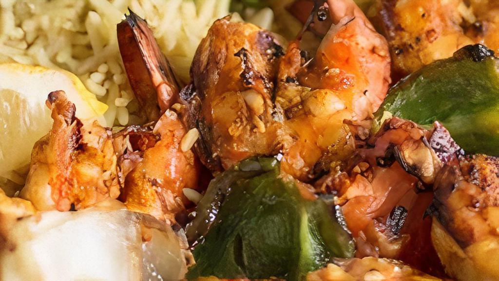 Moroccan Shrimp Kabob · Jumbo shrimp marinated in lemon, vinegar, and olive oil. Seasoned and charcoal grilled. Served with grilled tomatoes, onions, green peppers, and basmati rice.
