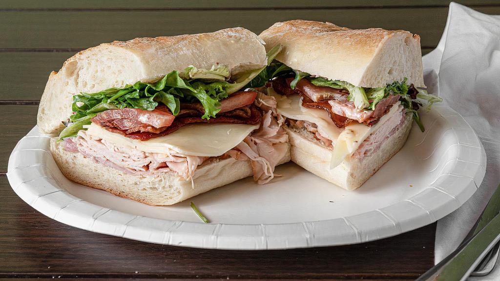 Club Sub · Roasted turkey and ham with bacon, provolone, tomatoes, organic greens, and house-made honey mustard on a French baguette.