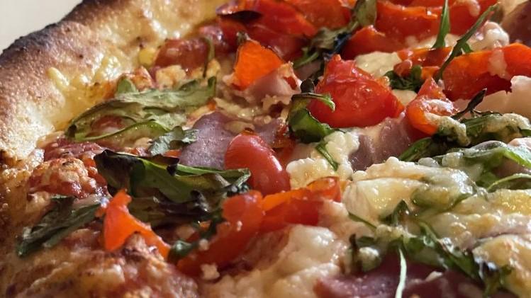 Basil Prosciutto Pizza · Basil pesto sauce, fresh mozzarella, feta cheese, artichokes, green olive.