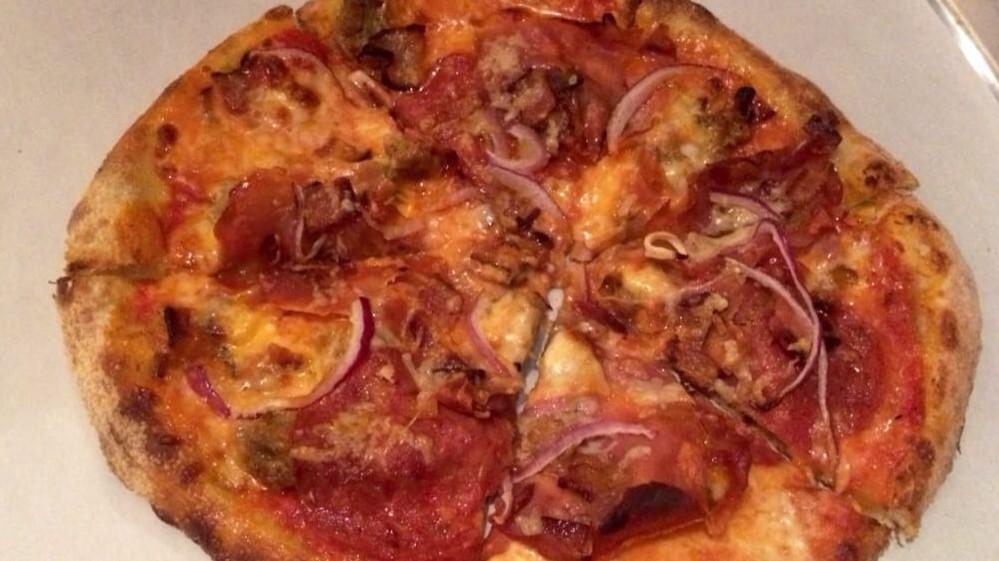 Ordinary Average Guy Pizza · Cajun sauce, pepperoni, Italian sausage, prosciutto ham, smoked bacon, cheese blend, fresh mozzarella, jalapeños, red onions.