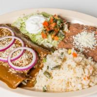 Enchiladas Con Mole · Three baked corn tortillas with choice of meat, lettuce, tomato, sour cream and cheese, acco...