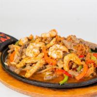 Sánchez Fajitas · Prepared with shrimp, beef, chicken, chorizo, bell peppers, onions, rice, beans, lettuce, pi...