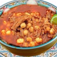 Posole · Hominy sup boiled with pork meat and red sauce garnishes such as onion, silantro, arbol pepp...