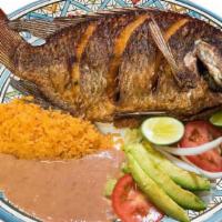 Mojarra · Tilapia fish are cooked fried in oil spicy Sal and pepper garnishes such as rice, beans, let...