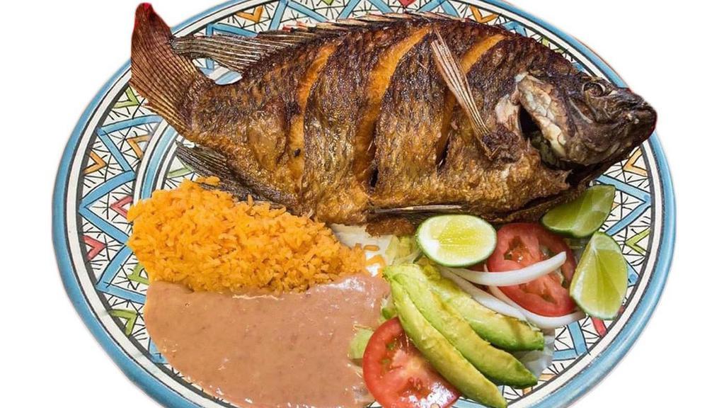 Mojarra · Tilapia fish are cooked fried in oil spicy Sal and pepper garnishes such as rice, beans, lettuce, tomato, avocado, onion and corn tortillas.