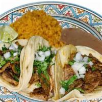 Combo Tacos · Three soft tacos prepared whit silantro, onion and salsa garnishes rice and beans.