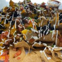 Mega Nachos · 2 layers of nacho cheese, scallions, black olives, taco beef, tomatoes, & sour cream poured ...