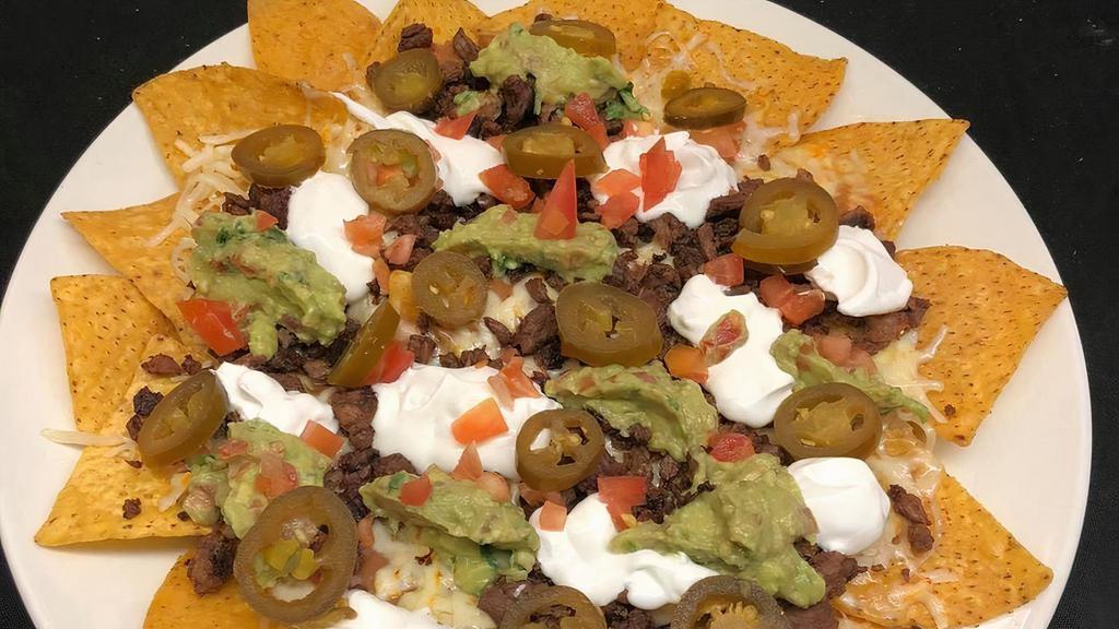 Nachos · Served with refried beans, tomato, jalapeño, cheese, sour cream and guacamole. Your Choice of chicken, pork or beef grilled chicken, steak, pastor or carnitas (extra charge).
