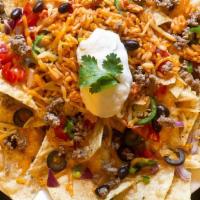 Chicken Nachos · Pulled chicken brushed with BBQ sauce and served over freshly-made tortilla chips with sour ...