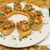 Bruschetta Di Roma · Toasted old world bread topped with a blend of diced tomatoes, fontinella cheese, and pesto.