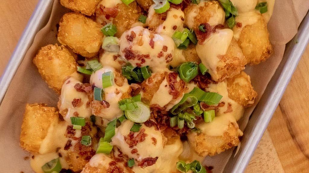 Smothered Tots · Tater Tots Smothered In House-Made Queso, Chopped Bacon & Green Onion.