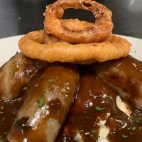Bangers & Mash · Creamy garlic mashed potatoes and English bangers with an herbed beef stock reduction and on...