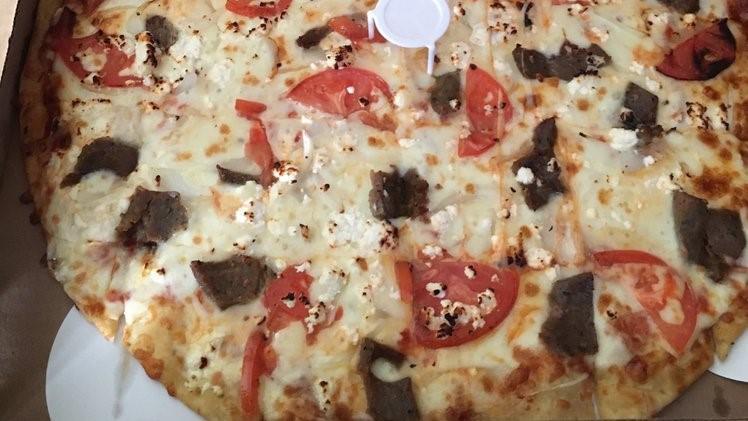Gyro Pizza · Cheese, Gyro Meat, Onions, Feta Cheese, Tomatoes, and Tzatziki Sauce on the side.