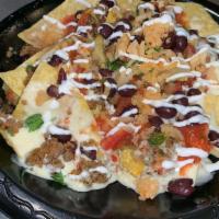 Nachos · Comes with fresh made chips, beans, choice of meat, queso and choose from all our toppings!
