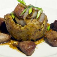 Pork Tenderloin With Mofongo · Sautéed chunks of pork tenderloin in onions and wine. Served with fried crush
plantains in o...