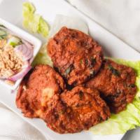 Tod Marn Gai · Hot. Four (4) golden-fried, spicy chicken cakes, served with a ground peanut on cucumber sau...