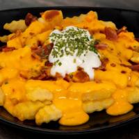 Smothered Cheese Fries · Straight cut potato fries smothered in queso, topped with sour cream chives, and sprinkled w...