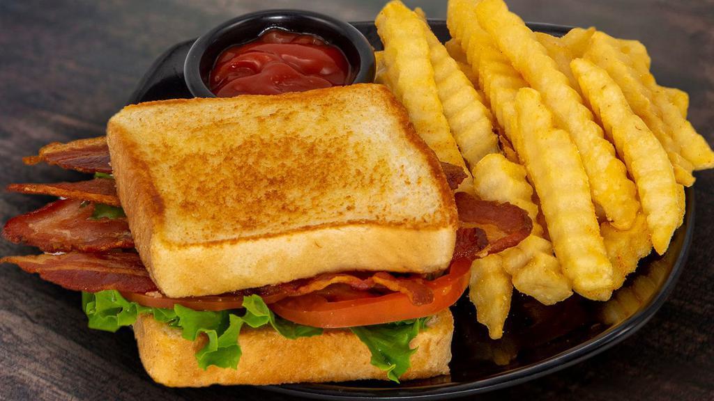 Blt · Four strips of bacon, lettuce, and tomato on bread.