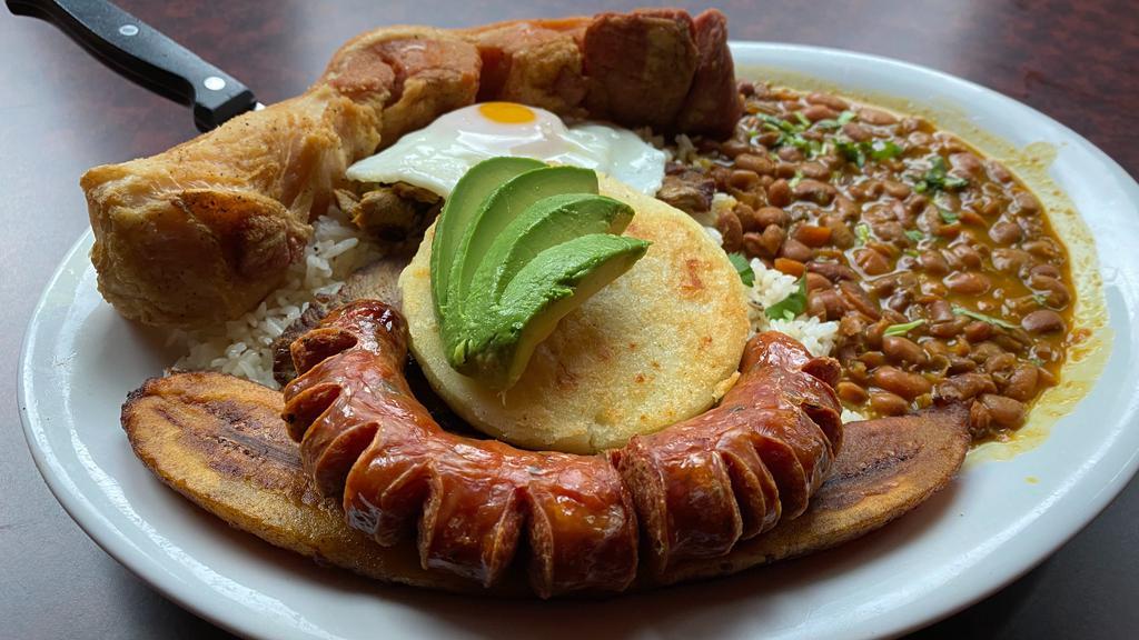 Bandeja Paisa · Grill grill top round steak with rice, beans, fred ege, colombian sausage, corn cake, crackling, avocado, sweet plantaing and cilantro.