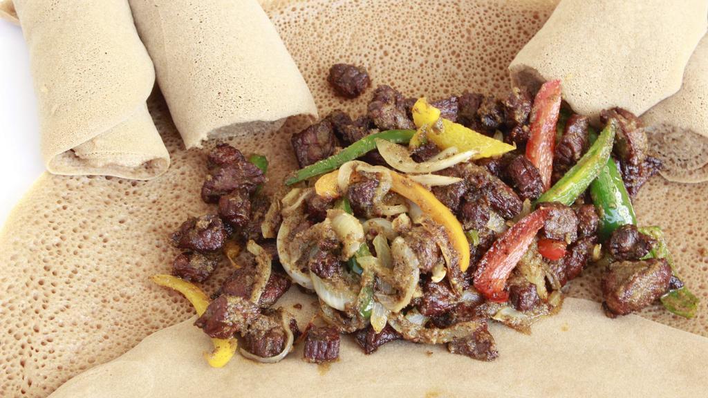 #17. Derek Tibs · Chopped prime beef marinated with Adama special sauce, onions, tomatoes and peppers cooked with butter served on budenna (injera). Cooking options: well-done, medium.