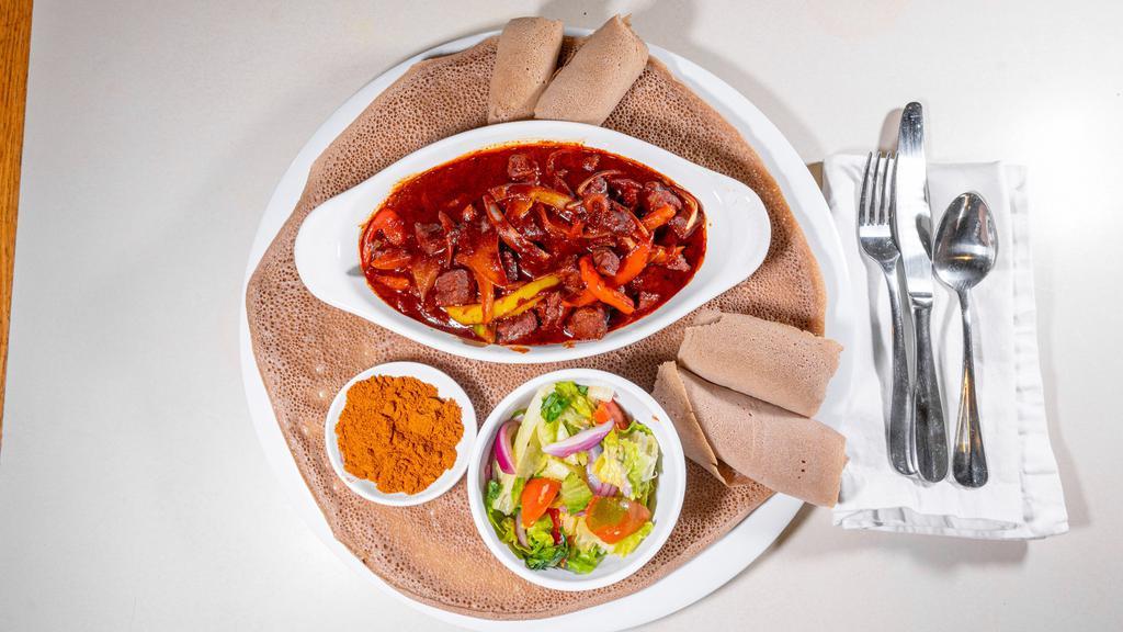 #15. Awaze Tibs (Spicy) · Chopped prime beef, onions, tomatoes and peppers cooked with butter served on budenna (injera).