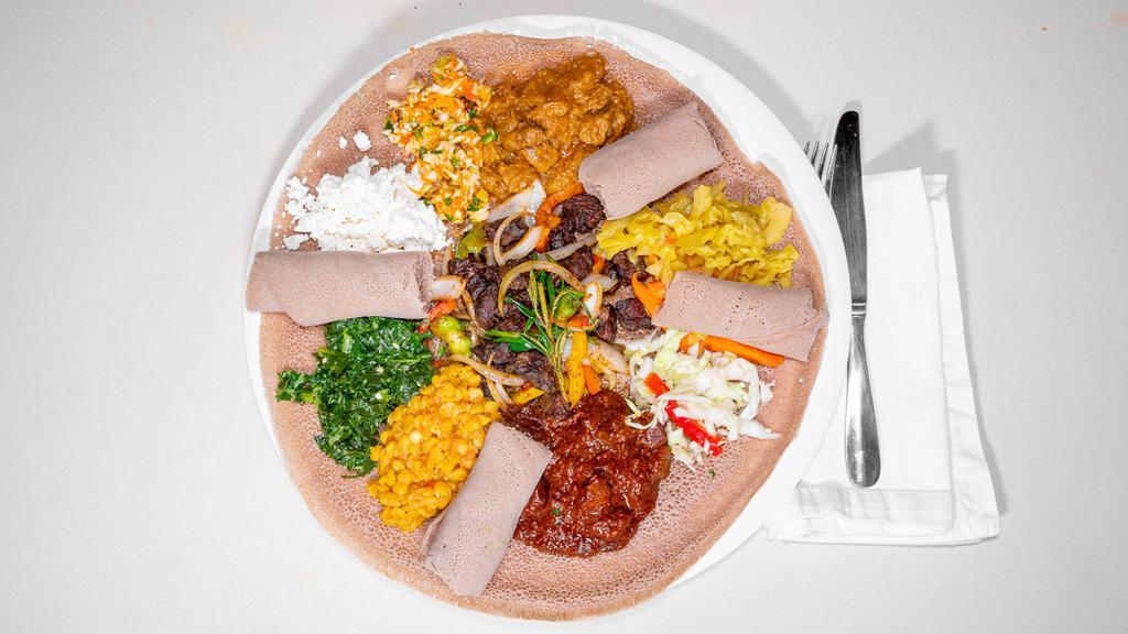 #27. Adama Combo 1 · Combination of alecha misir wot, tibs, keye wot, alecha wot, Collar green, cabbage & spiced cottage cheese served on budenna (injera) .