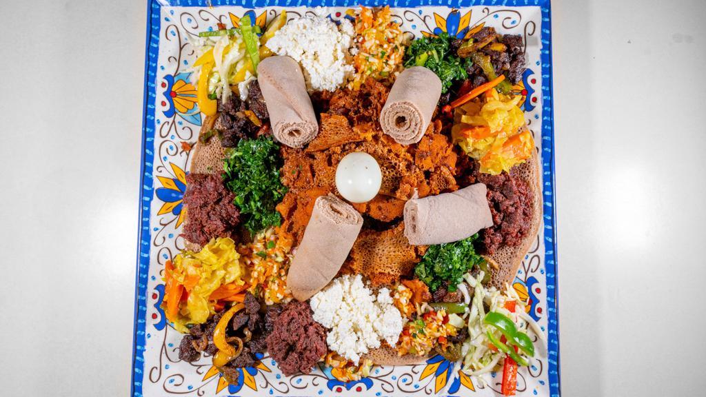 #28. Adama Combo 2 · Combination of derek tibs, kitfo, quanta firfir, spiced cottage cheese, collard greens, cabbage with carrot and boiled egg served on budenna (injera) .