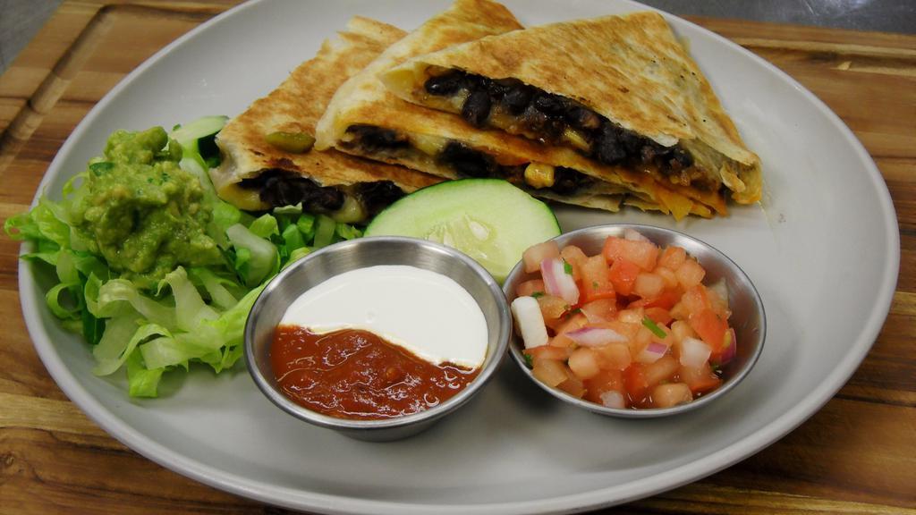 Black Bean Quesadilla · Grilled tortilla filled with mozzarella cheese, black beans, onion + cilantro with choice of salsa. Served with lettuce, pico and sour cream on the side.