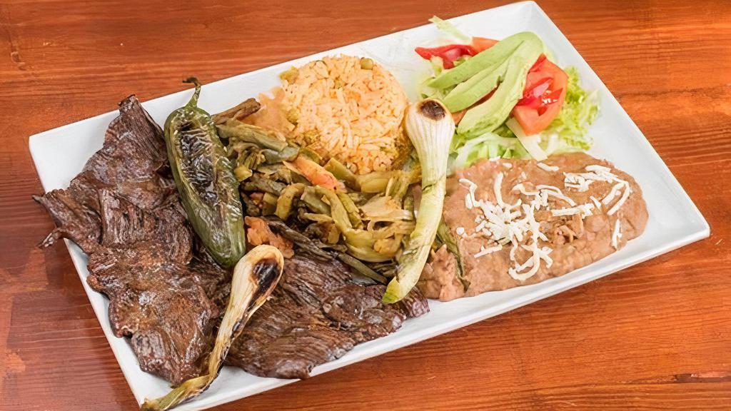 Carne Asada Con Nopalitos · Grilled tender skirt steak. Served with cactus slices, grilled jalapeno, grilled onions, rice, beans, salad and avocado.